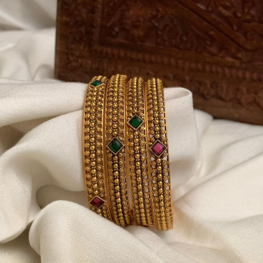 Premium antique gold-plated bangles feature traditional Kemp stones in green and ruby red set of 4 bangles