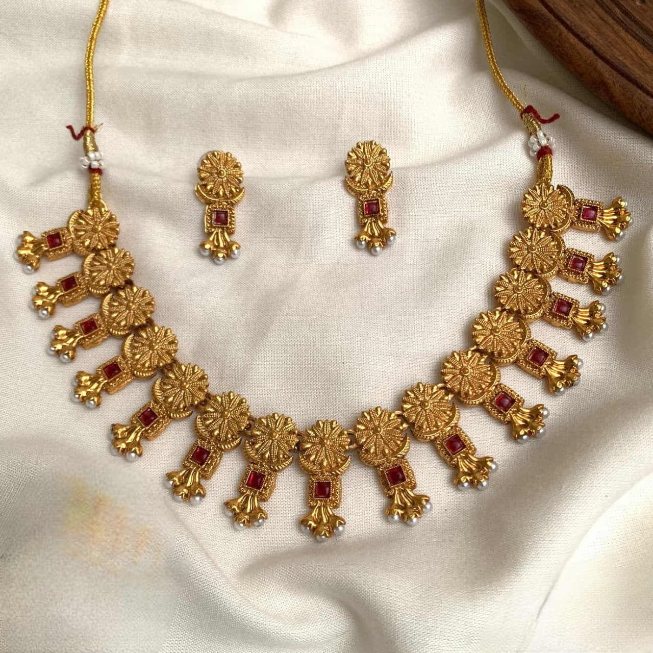 These are antique-style imitation gold-plated necklace sets featuring red and green  stone accents and hanging pearl details product code T68