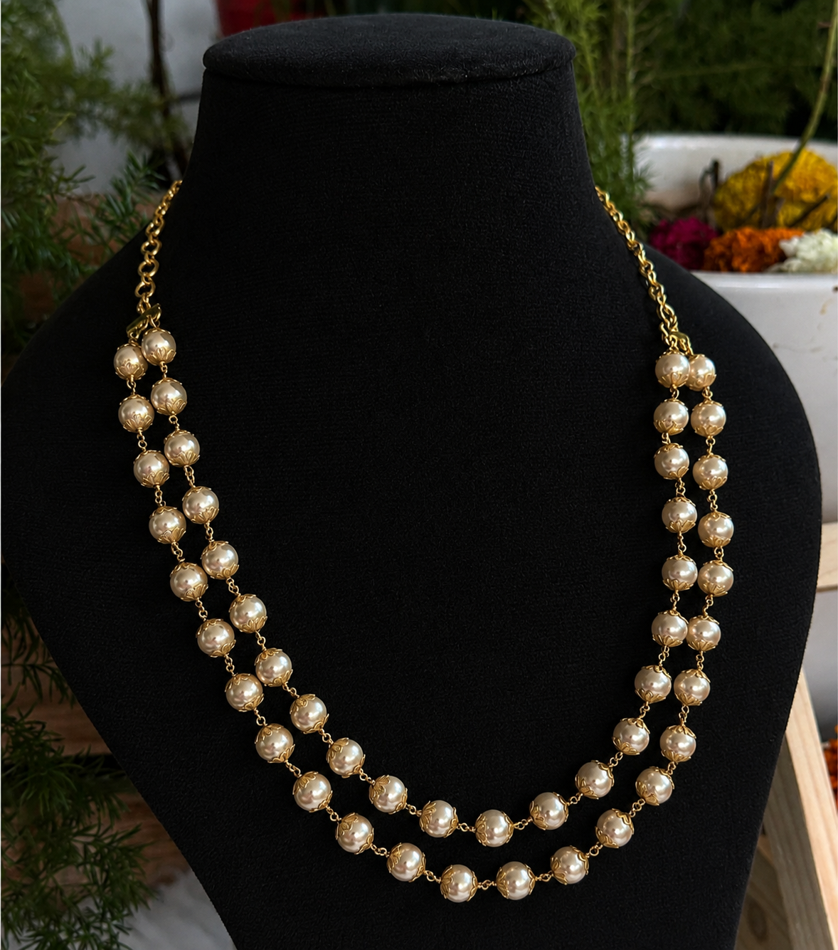 Premium traditional Hyderabad-style pearl necklace features two layers of lustrous white pearls accented by intricate gold-plated beads product code P112