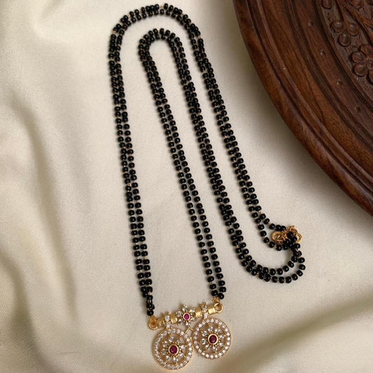 Premium micro gold-plated black beads mangalsutra featuring a dual circular pendant adorned with ruby and American diamond stones product code T67