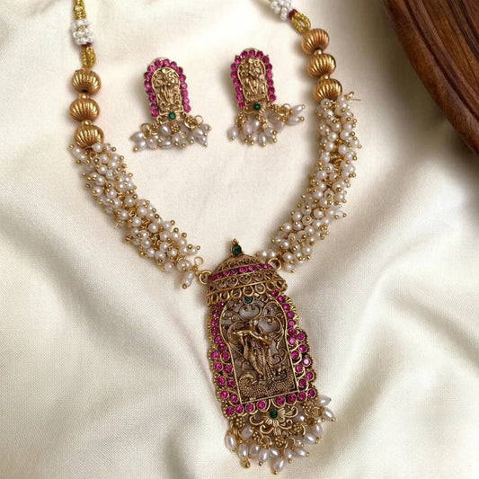 Premium handcrafted temple jewellery necklace and earring set featuring a Radha Krishna pendant and pink stone embellishments product code T62