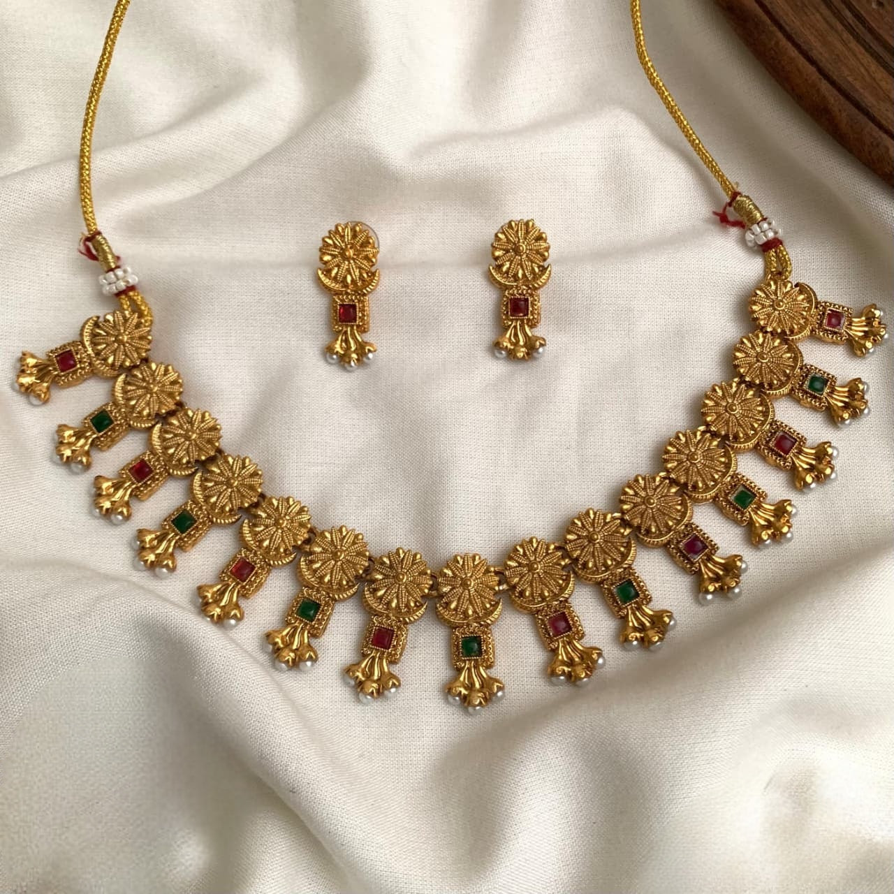 These are antique-style imitation gold-plated necklace sets featuring red and green  stone accents and hanging pearl details product code T68