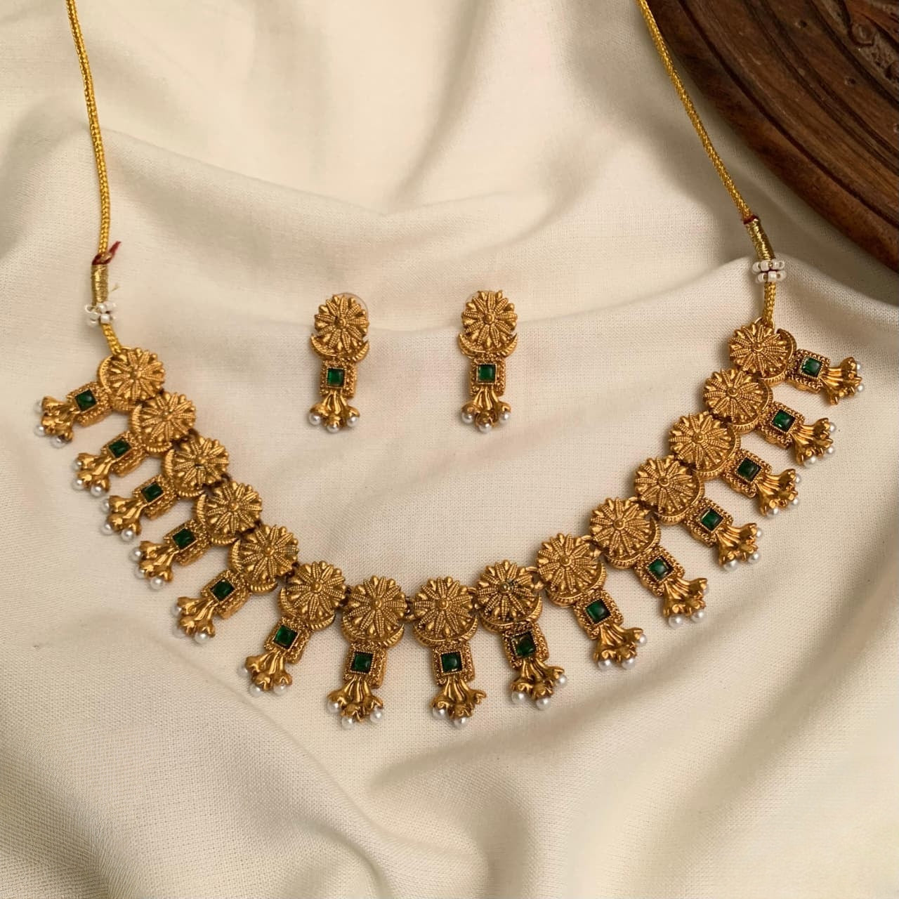 These are antique-style imitation gold-plated necklace sets featuring red and green  stone accents and hanging pearl details product code T68